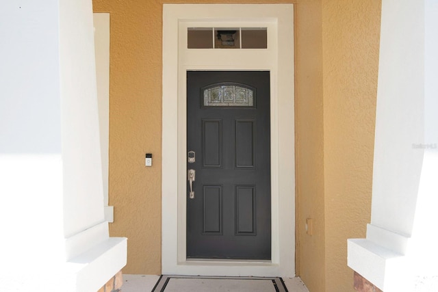 view of exterior entry featuring stucco siding