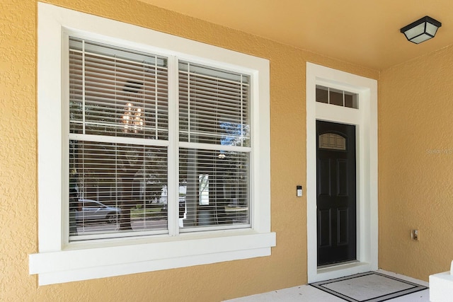 property entrance with stucco siding