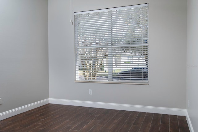 empty room with baseboards and wood finished floors