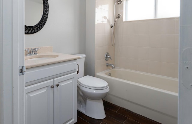 full bath with wood tiled floor, bathing tub / shower combination, toilet, and vanity