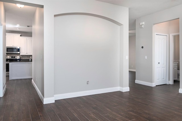 hall featuring dark wood-style flooring, recessed lighting, and baseboards