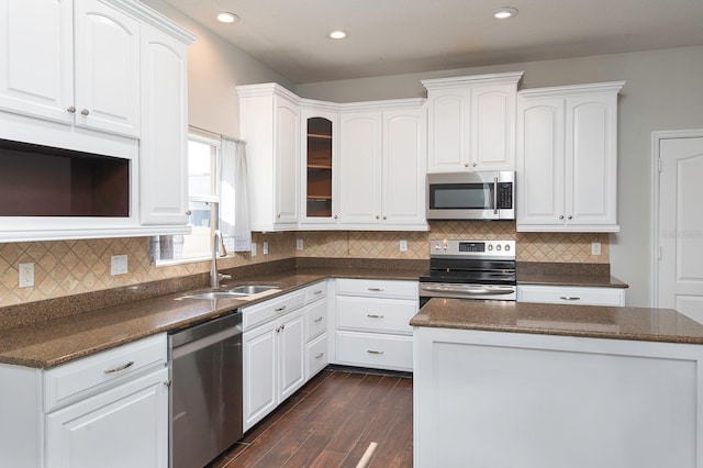 kitchen with stainless steel appliances, white cabinetry, a sink, and dark wood-type flooring