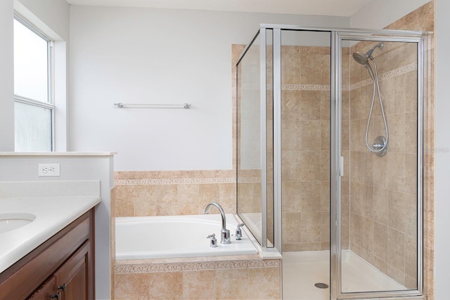 full bathroom featuring a garden tub, a shower stall, and vanity