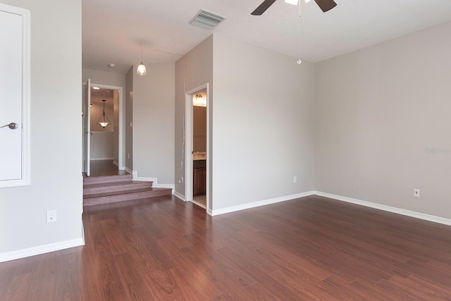 spare room with ceiling fan, baseboards, visible vents, and dark wood finished floors