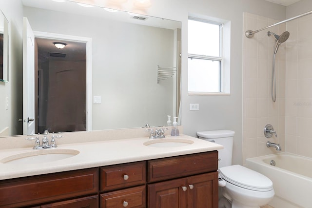 bathroom with visible vents, double vanity, a sink, and toilet