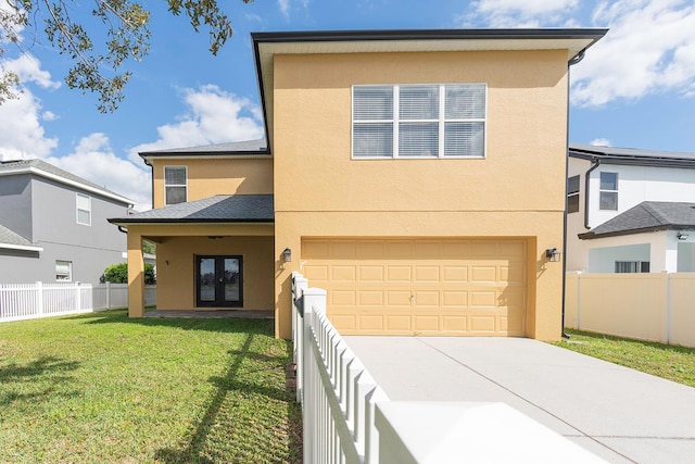 view of front of home with french doors, stucco siding, fence, driveway, and a front lawn