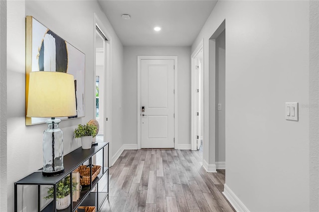 interior space featuring recessed lighting, baseboards, and wood finished floors