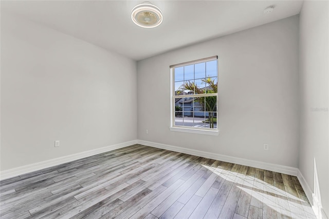 unfurnished room with baseboards and wood finished floors