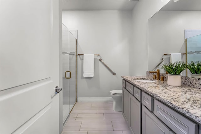 bathroom featuring tile patterned floors, toilet, a stall shower, baseboards, and vanity