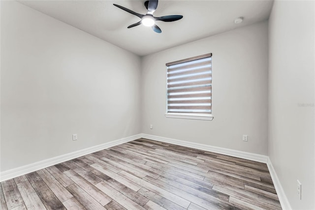 empty room featuring baseboards, wood finished floors, and a ceiling fan