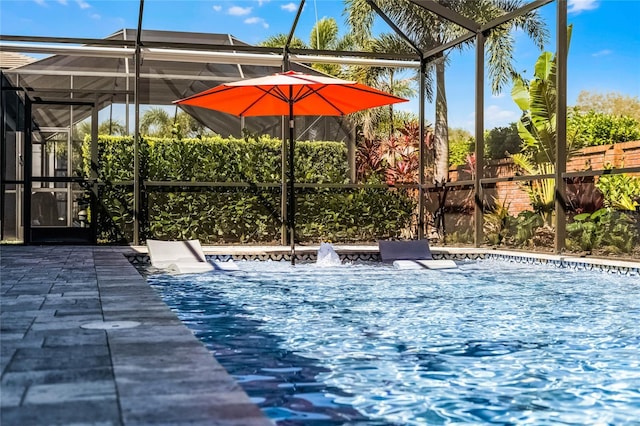 view of pool featuring glass enclosure, a patio, and fence