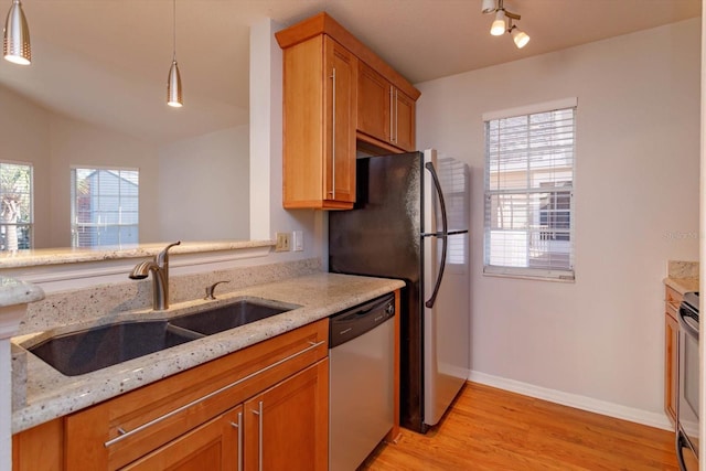 kitchen featuring a sink, a wealth of natural light, light wood-style floors, and dishwasher