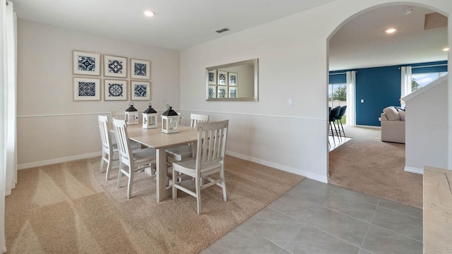 tiled dining room featuring arched walkways, recessed lighting, carpet flooring, visible vents, and baseboards