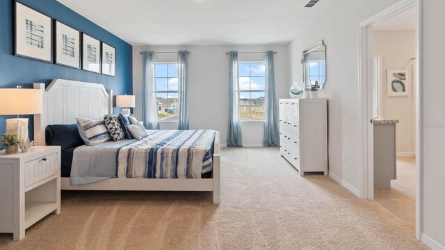 bedroom featuring baseboards, visible vents, and light colored carpet