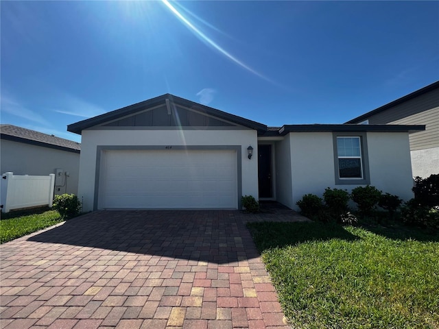 single story home featuring decorative driveway, fence, an attached garage, and stucco siding