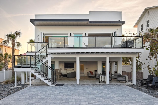 back of house featuring stairway, fence, stucco siding, and a patio