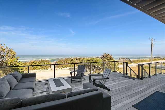 wooden terrace featuring a view of the beach, a water view, and an outdoor hangout area