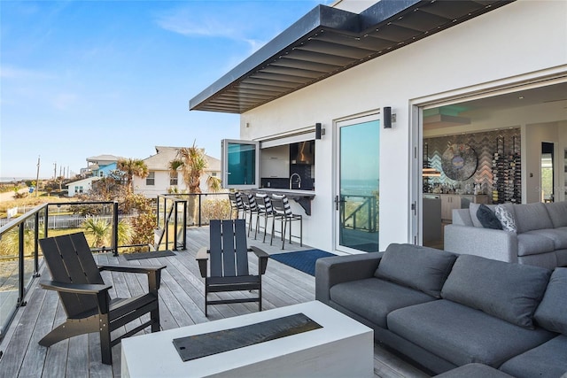 deck featuring outdoor dry bar, an outdoor living space, and a sink