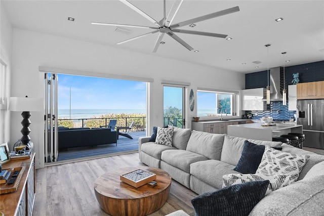 living area with light wood-style floors, recessed lighting, and a ceiling fan