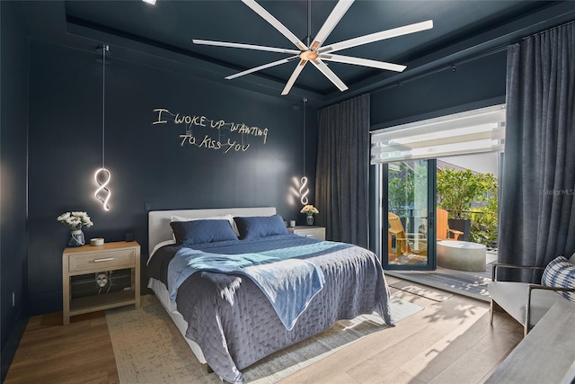 bedroom featuring access to exterior, a ceiling fan, and wood finished floors