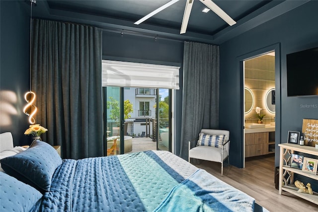 bedroom featuring access to outside, ensuite bath, and wood finished floors