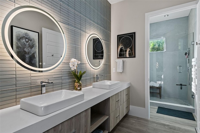 full bathroom with a shower stall, tile walls, and a sink