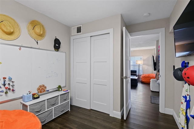 bedroom featuring baseboards, visible vents, dark wood finished floors, and a closet