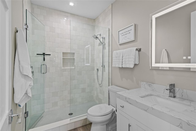 full bath with vanity, a shower stall, and toilet