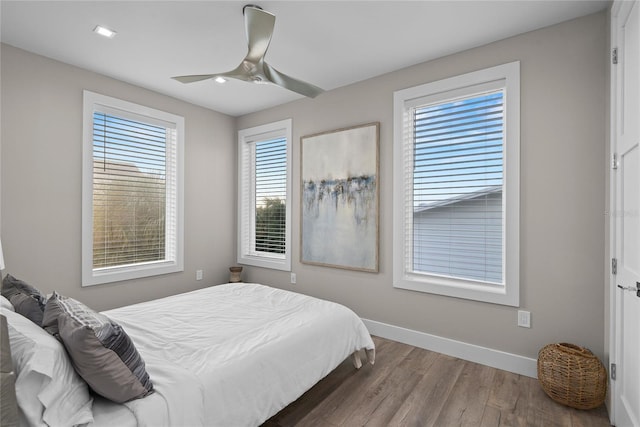 bedroom featuring wood finished floors, a ceiling fan, and baseboards