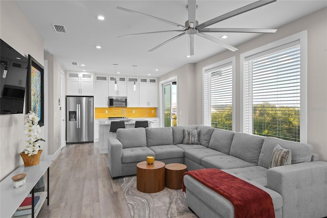 living area with recessed lighting, visible vents, ceiling fan, and light wood finished floors