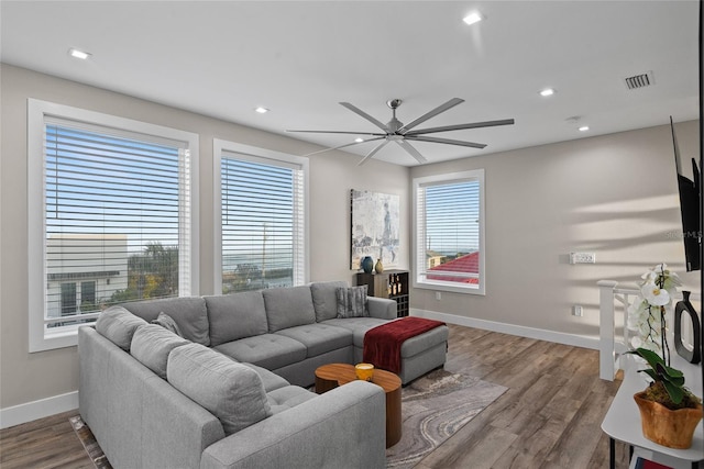 living area featuring dark wood-type flooring, recessed lighting, visible vents, and baseboards