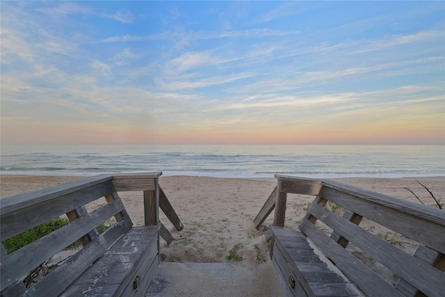 surrounding community with a water view and a beach view