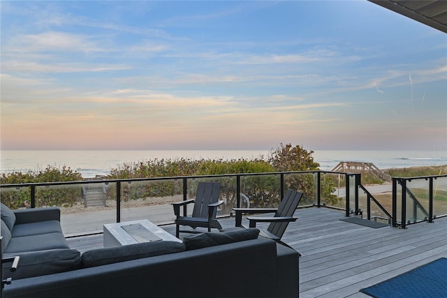 deck at dusk with a water view and an outdoor living space