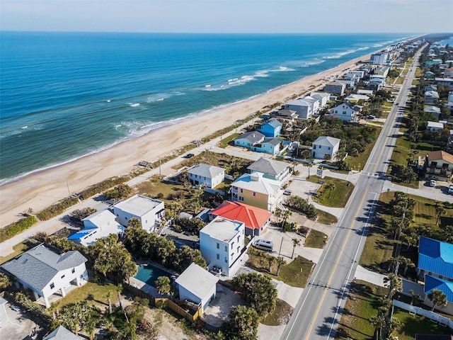 birds eye view of property with a water view and a view of the beach