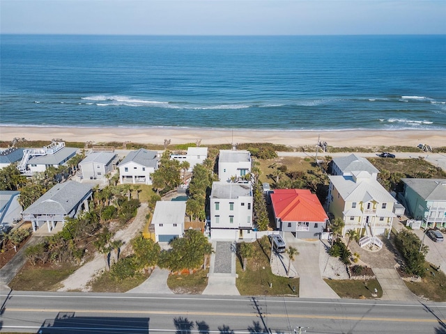 drone / aerial view featuring a view of the beach, a residential view, and a water view