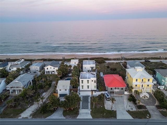 drone / aerial view with a residential view, a view of the beach, and a water view