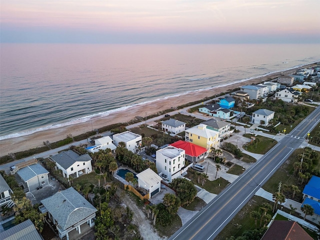 drone / aerial view with a beach view, a residential view, and a water view