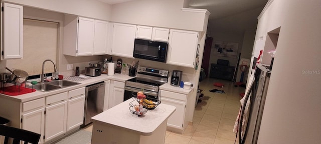 kitchen featuring light tile patterned floors, a sink, white cabinetry, light countertops, and appliances with stainless steel finishes