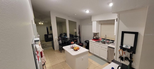 kitchen featuring a sink, white cabinetry, light countertops, a center island, and dishwasher