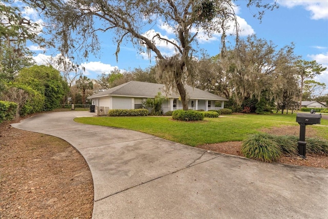 view of front of property featuring a garage, concrete driveway, and a front yard