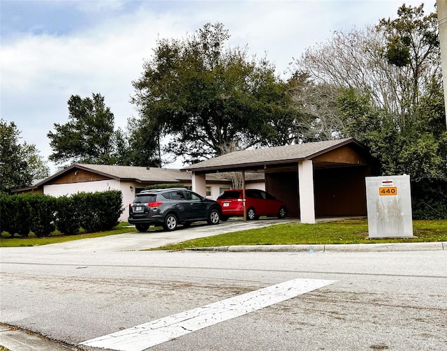 view of parking / parking lot featuring concrete driveway