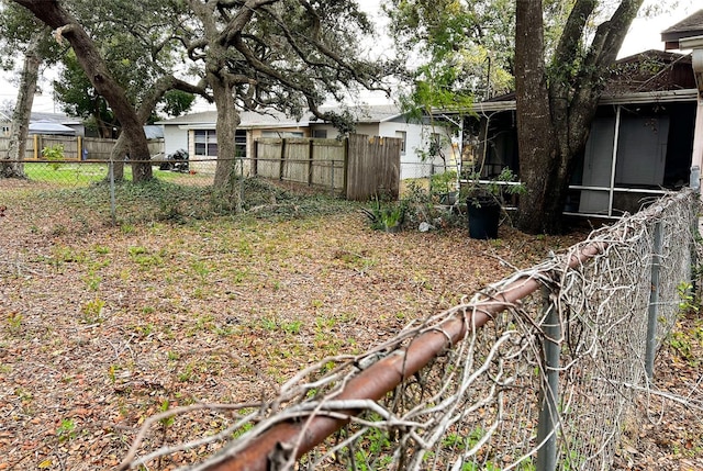 view of yard featuring fence and a sunroom