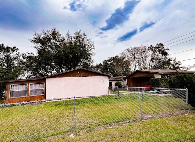 view of home's exterior with a yard, a carport, and fence