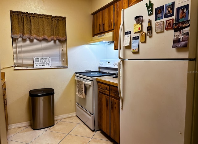 kitchen featuring light tile patterned floors, white appliances, exhaust hood, baseboards, and light countertops