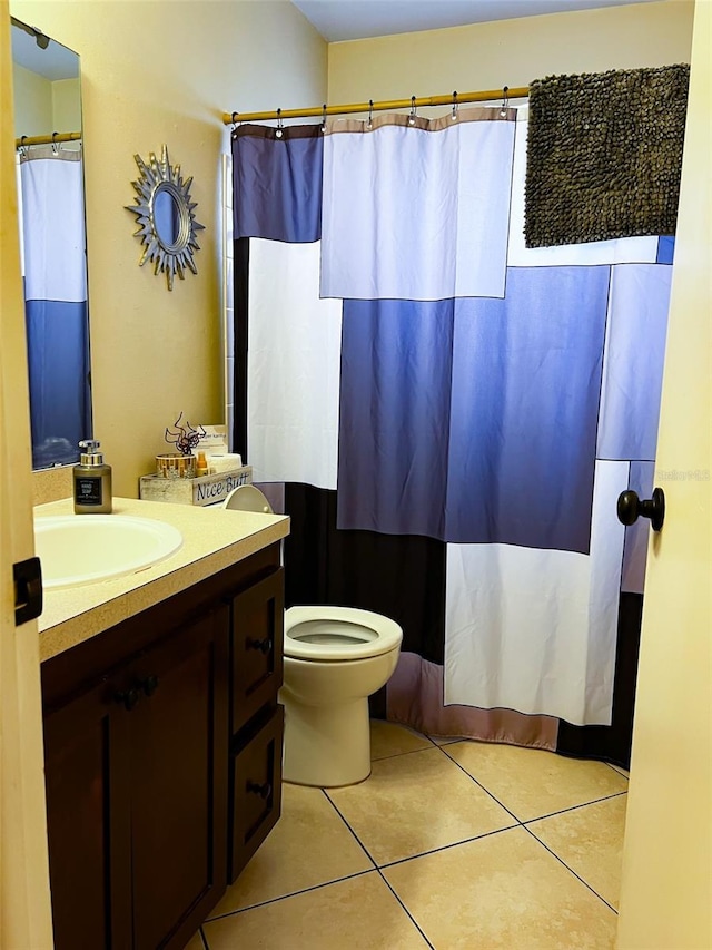 bathroom featuring curtained shower, vanity, toilet, and tile patterned floors