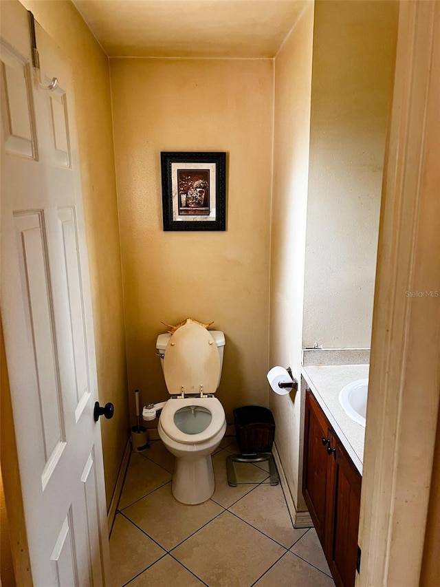 bathroom featuring toilet, tile patterned flooring, and vanity