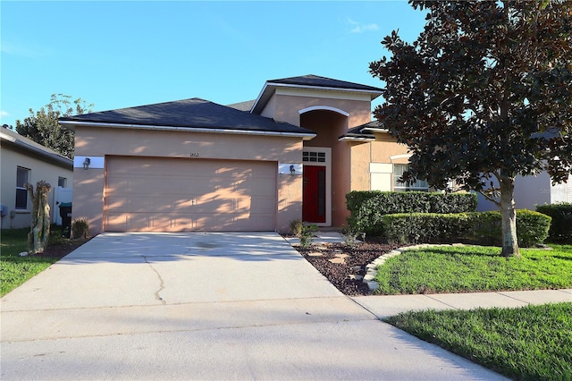 view of front of house featuring concrete driveway, an attached garage, and stucco siding