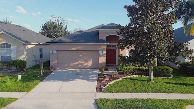 view of front of property with a garage, driveway, a front yard, and stucco siding