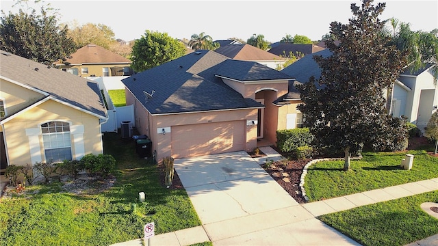 view of front of home featuring central air condition unit, a garage, concrete driveway, a residential view, and a front yard