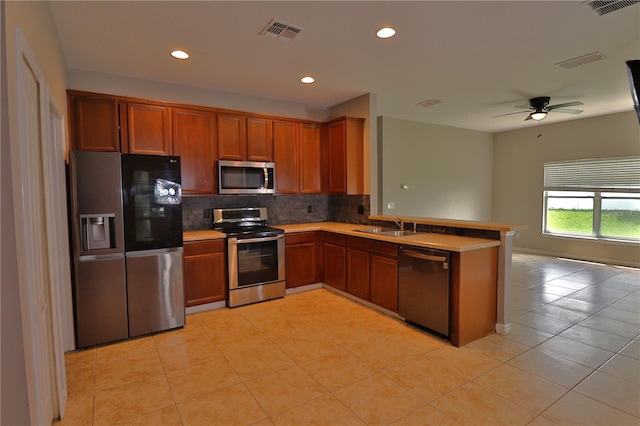 1862 Great Falls Way, Orlando, FL 32824 - kitchen featuring stainless steel appliances, backsplash, a peninsula, light tile patterned floors, and a ceiling fan